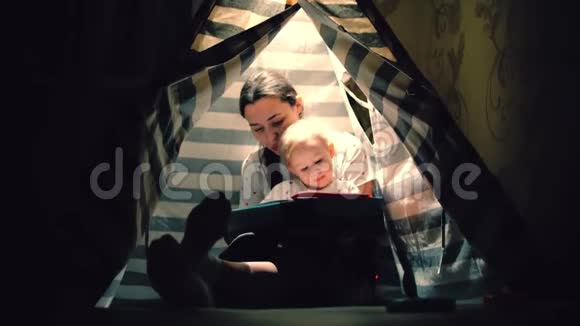 晚上妈妈和她的小宝贝一起在一个小茶壶里读一本书视频的预览图