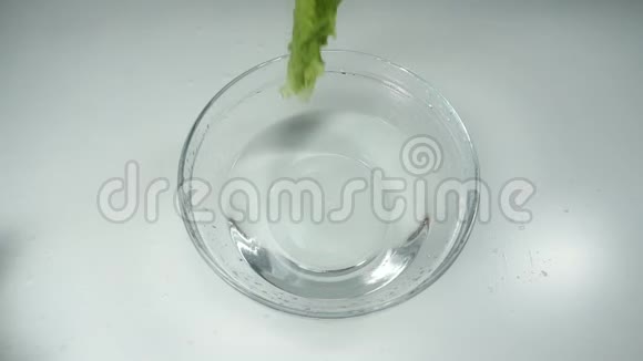 慢动作生菜在桌上的玻璃碗里掉进水里新鲜有机蔬菜健康饮食视频的预览图