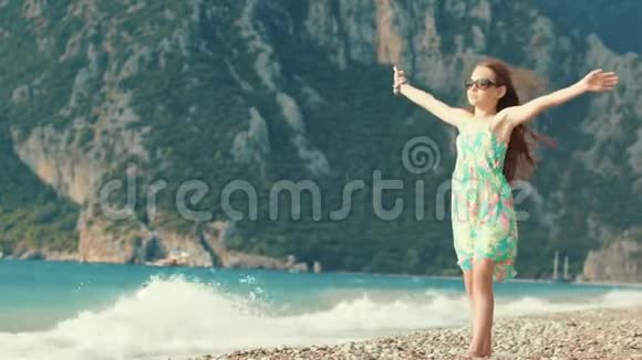 漂亮女孩喜欢在海边度假孩子向山上张开双臂视频的预览图