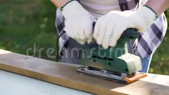 近距离手工艺品妇女手在工作手套砂木木板与砂轮机视频的预览图