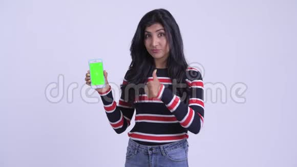 快乐的年轻美丽的波斯女人展示电话和竖起大拇指视频的预览图