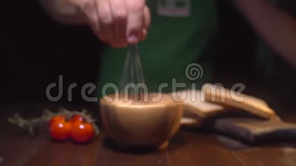 厨师用搅拌器搅拌碗里的酱汁男人在厨房做饭配料做酱汁做酱汁视频的预览图