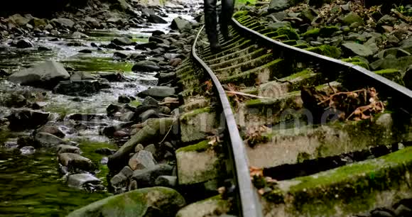 一位游客在废弃的森林铁轨上散步视频的预览图