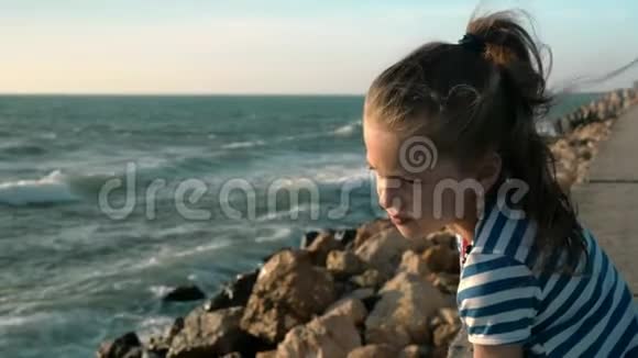 海滩上的小女孩日落时刮风的一天概念孤独视频的预览图