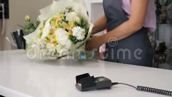 人在花店买花束在支付终端刷卡支付双手特写视频的预览图