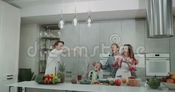 厨房里充满魅力和微笑的一家人一起玩泡泡一起跳舞视频的预览图