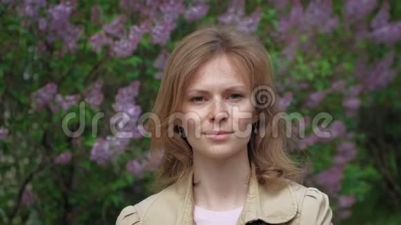 淡紫色灌木背景下的年轻女子视频的预览图