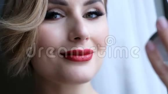漂亮的女人带着专业的化妆看着相机送一个吻和微笑视频的预览图
