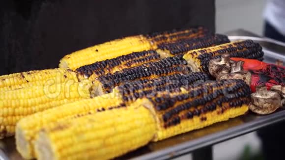 把美味的烧烤玉米放在烤鹅卵石上用发光的煤烤视频的预览图