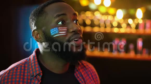 非裔美国人足球迷脸上挂着旗子为球队获胜而欢呼视频的预览图