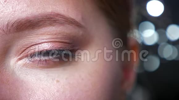 美丽的白种人女人用亲切的目光直视镜头的绿色眼睛上的特写眼影视频的预览图