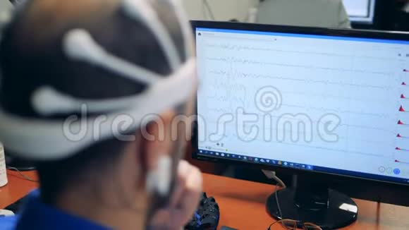 一个工人在头上戴传感器时检查他的大脑背面的视图视频的预览图