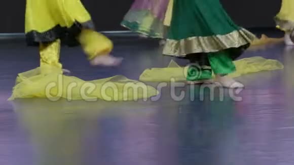 印度舞蹈舞台上年轻舞者脚的特写黄色和绿色的衣服视频的预览图