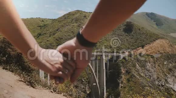 近距离的男人和女人携手走在史诗般美丽的景色比克斯比溪桥在大南加州视频的预览图