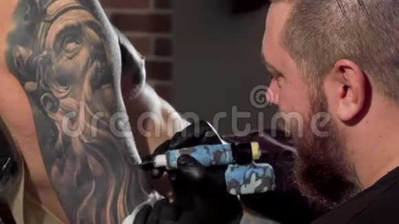 一名男子当事人手臂上的纹身师的后视镜头视频的预览图