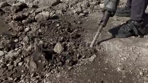 一个人和一个手提钻一起工作一个凿岩机打破了沥青大型和重型道路修理工具视频的预览图