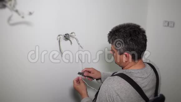 工人准备电线连接石膏墙孔中的插座花环框架视频的预览图