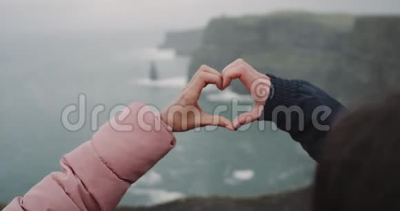 莫赫悬崖上的两只冻僵的手的特写细节使人从手中得到了一颗巨大的心4k视频的预览图