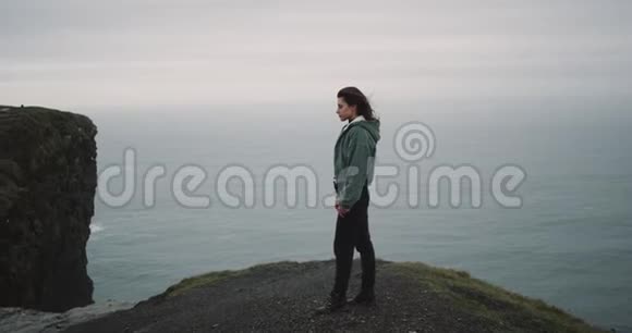 在悬崖顶上一个年轻的女人欣赏风景她对周围的风景印象深刻视频的预览图