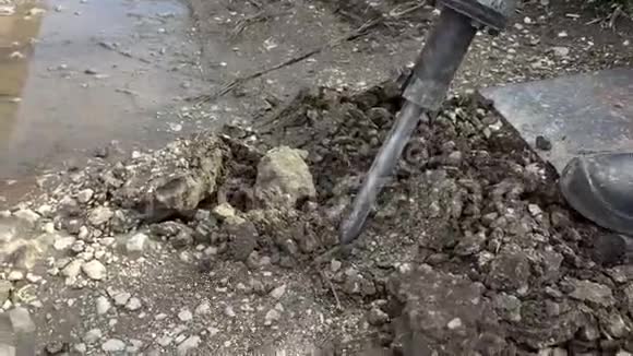 一个人和一个手提钻一起工作一个凿岩机打破了沥青大型和重型道路修理工具视频的预览图