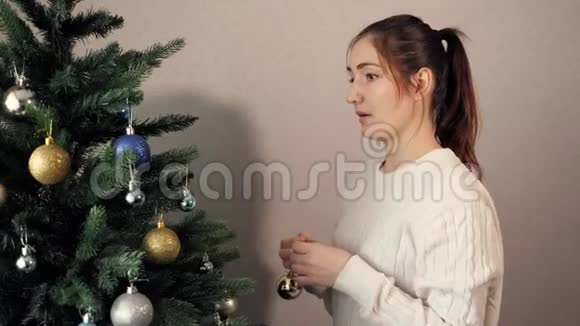 扎着马尾装饰圣诞树的快乐小姐视频的预览图