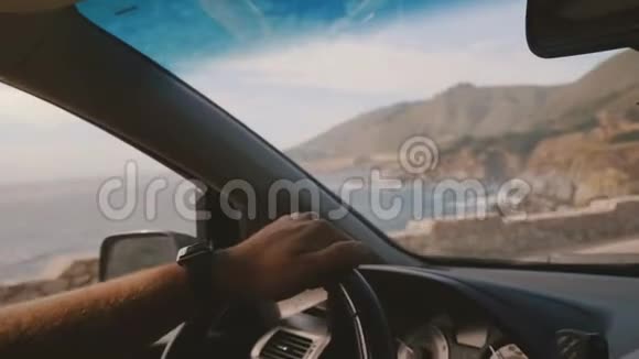 美丽的车内镜头男性手握汽车方向盘沿史诗海岸线道路行驶在大南加州视频的预览图