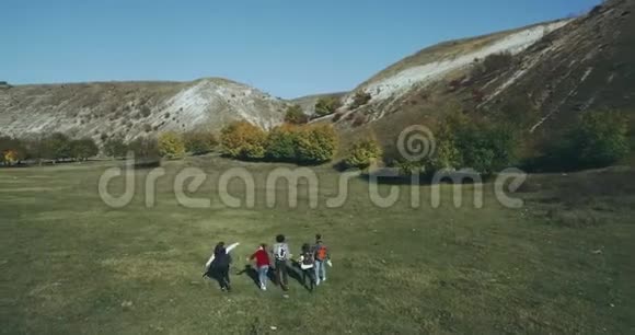 无人机从空中拍摄视频一大群朋友一起旅行在大自然中他们快乐地一起散步视频的预览图
