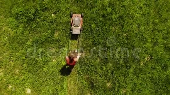 女孩用电动割草机在他的院子里割草视频的预览图