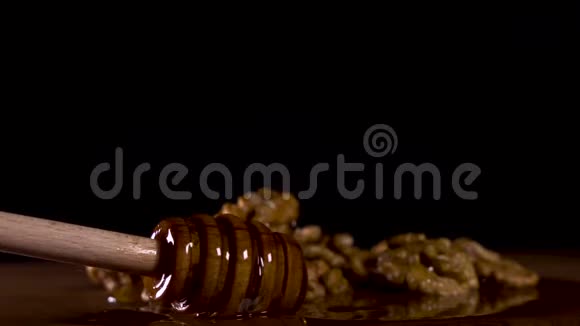 把蜂蜜勺子放在木板上坚果里放着美味的蜂蜜视频的预览图