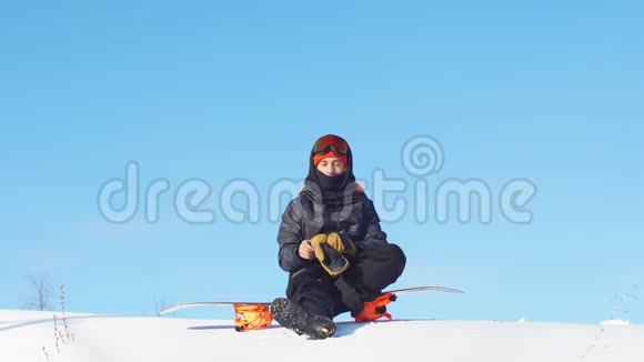 戴着滑雪面具和运动夹克的年轻帅哥盯着镜头视频的预览图