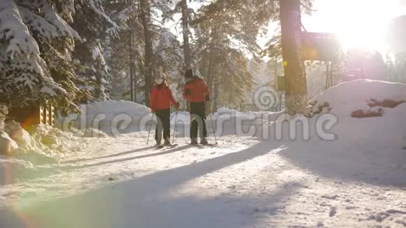 恋爱中的情侣在最后的阳光下在滑雪场散步滑雪视频的预览图