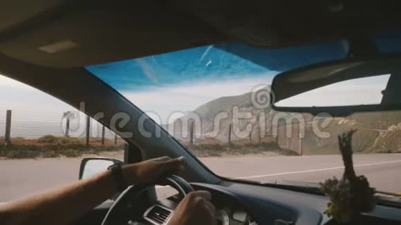大气POV拍摄的男子驾驶在难以置信的阳光海洋海岸道路与山景在大南加州视频的预览图