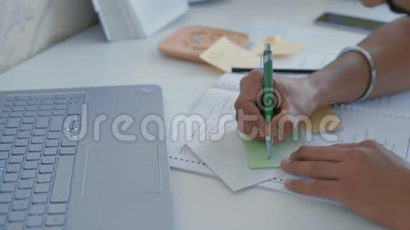 特写印度学生的手在贴纸上画一块平板视频的预览图