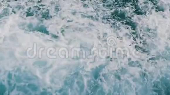 美丽的绿松石海水与波浪和白色泡沫接近顶部视图船浮在海面上破浪前进视频的预览图