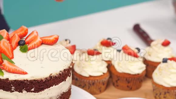 一家女厨师咖啡馆的特写用手装饰蛋糕带草莓和奶油蛋糕视频的预览图