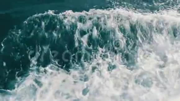 美丽的绿松石海水与波浪和白色泡沫接近顶部视图船浮在海面上破浪前进视频的预览图