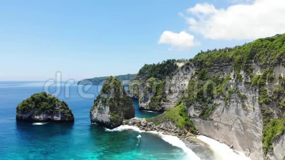 空中无人机观赏热带海滩海岩绿松石海洋和棕榈树巴厘NusaPenida岛Atuh海滩视频的预览图