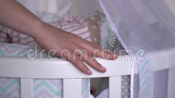 怀孕的女孩把她的手放在婴儿床和中风的腹部视频的预览图