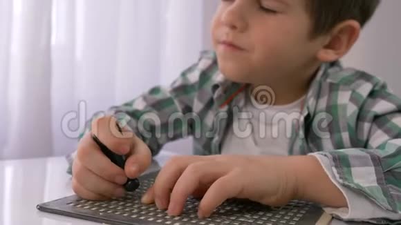 盲童教育生病的小男孩在明亮的桌子上学习书写字体盲文视频的预览图