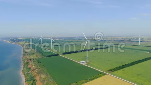阳光明媚的一天绿茵场上有许多风力涡轮机沿着海岸视频的预览图