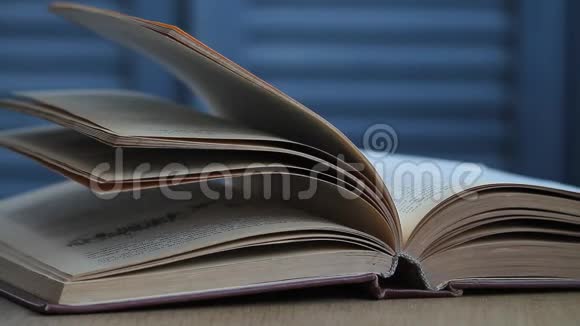 桌上一本打开的书的特写书页在风中摇曳视频的预览图