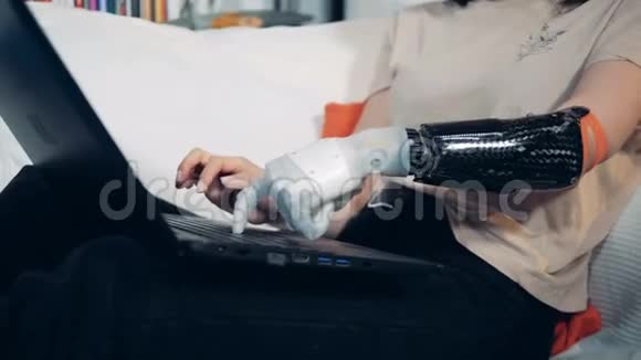 一个女人用机器手在笔记本电脑上打字关闭视频的预览图