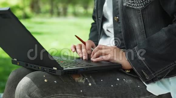 在公园里用笔记本电脑接近女人视频的预览图