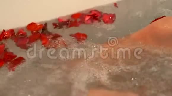 女人用玫瑰花瓣洗澡浪漫的浴室为蜂蜜月或爱情约会女人抚摸玫瑰花瓣视频的预览图