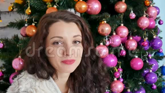圣诞节的概念美丽的卷曲黑发在背景上微笑的创造性装饰圣诞树关门视频的预览图