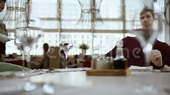 服务员给男人菜单商务午餐餐厅服务这个人正坐在一家现代化的咖啡馆里那里很漂亮视频的预览图