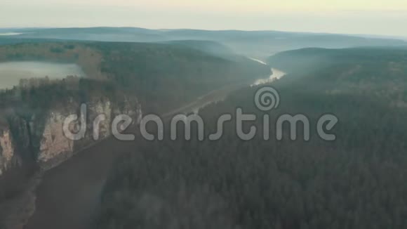 一幅美丽的雾蒙蒙的河景和山上的云杉林视频的预览图