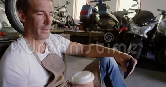 男机修工4k在摩托车修理厂喝咖啡视频的预览图