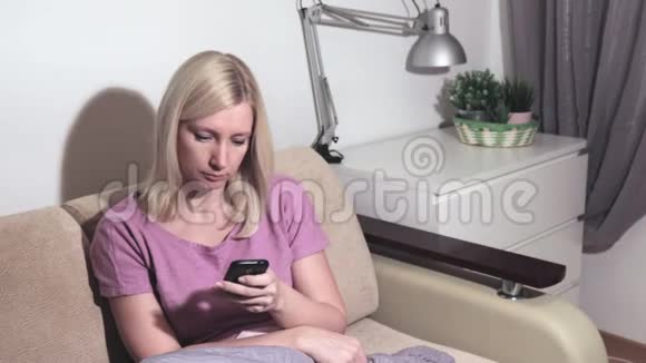 年轻的金发女郎在社交网络应用程序中回答朋友的信息搜索信息视频的预览图
