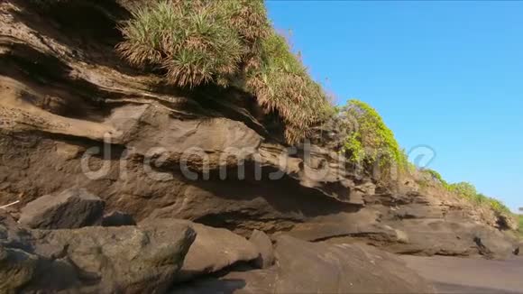 巴厘岛TanahLot神庙附近的一个岩石海滩海岸的慢镜头视频的预览图